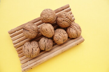 Orzechy włoskie z drewnianymi patyczkami na żółtym tle