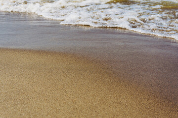 Wave on brown sand. Summer beach background