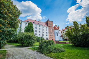 The Historic Castle of the Silesian Piast Dynasty in Brzeg. A historic residence from the 13th century. Museum. Renaissance castle. Gothic brick tower. White plastered facade with windows.