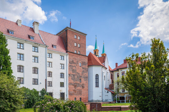 The Historic Castle of the Silesian Piast Dynasty in Brzeg. A historic residence from the 13th century. Museum. Renaissance castle. Gothic brick tower. White plastered facade with windows.