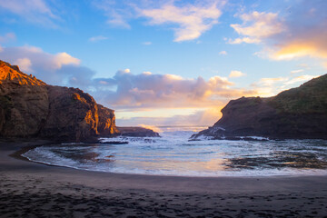 Beautiful lagoon and ocean beach in Piha, Auckland, New Zealand, before sunset.