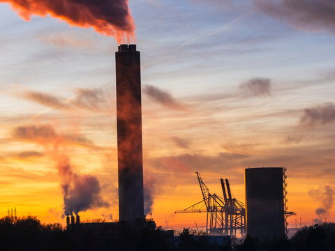 Poisonous smoke emitting from chimney near construction site under cloudy sky