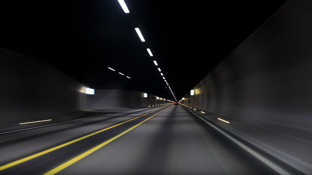 Blurred motion of car in illuminated tunnel