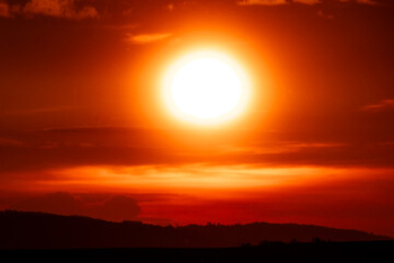 Close-up of the blazing sun dominating a vivid orange-red sky, creating a powerful visual of intense natural energy