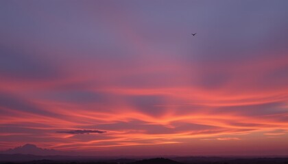 Fototapeta premium Serene Sunset Sky Vibrant Pink and Orange Hues over Distant Hills