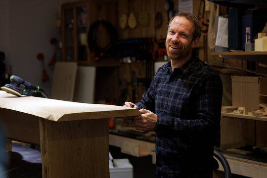 Portrait of happy carpenter working in workshop