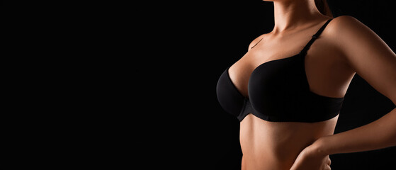 Naklejka premium Young woman in bra on black background, closeup