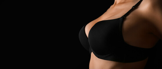 Naklejka premium Young woman in bra on black background, closeup