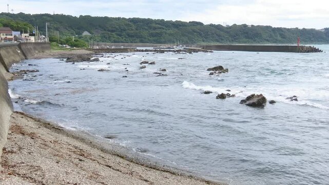 海の岩がある海岸に波が押し寄せる景色