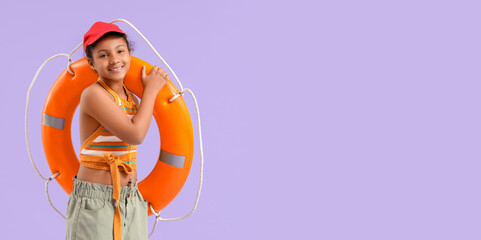 Happy African-American girl with ring buoy on purple background