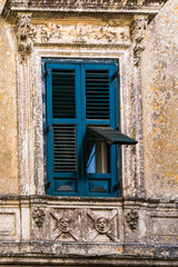 Ornate balcony and wooden door on historic Italian building facade