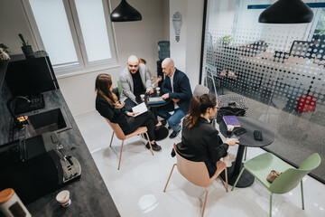 A group of coworkers engaged in a professional conversation while sitting in a contemporary office break area.