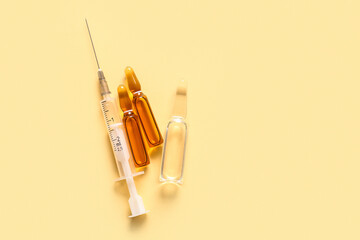 Ampules with syringe on light yellow background