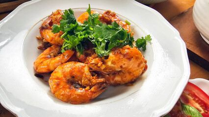 Enjoying eating delicious crispy garlic-fried shrimp and juicy stir-fried shrimp with fresh seafood with chopsticks— traditional Taiwanese stir-fry restaurant cuisine