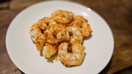 Enjoying eating delicious crispy garlic-fried shrimp and juicy stir-fried shrimp with fresh seafood with chopsticks— traditional Taiwanese stir-fry restaurant cuisine