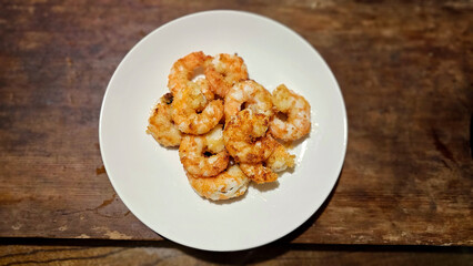 Enjoying eating delicious crispy garlic-fried shrimp and juicy stir-fried shrimp with fresh seafood with chopsticks— traditional Taiwanese stir-fry restaurant cuisine