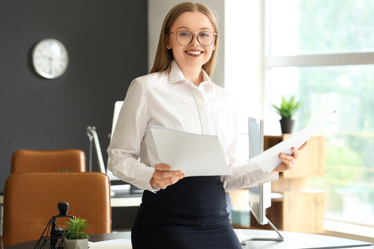 Fototapeta Young businesswoman working with documents in office