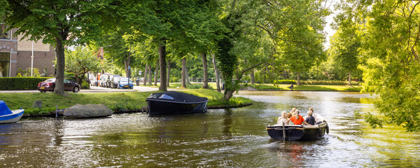 Group of female friends sailing the city canals in a sloop on a beautiful sunny day in Leiden in South-Holland The Netherlands