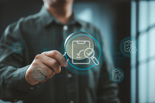 Businessman using digital magnifying glass to inspect audit and document icons - Powered by Adobe