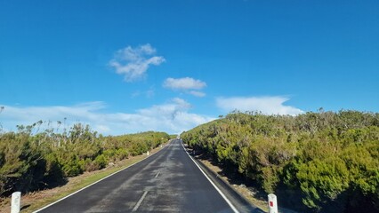 Obraz premium A road trip through Madeira reveals the island’s stunning diversity, from lush mountains and dramatic cliffs to charming villages and vibrant coastal views. Winding roads offer unforgettable experienc