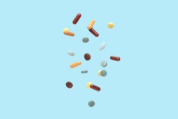 Flying different pills on blue background