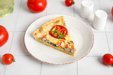 Plate with piece of delicious tomato tart on white tile background