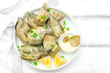Traditional italian artichoke «alla romana», cooked carciofi vegetable. Olive oil, garlic, parsley