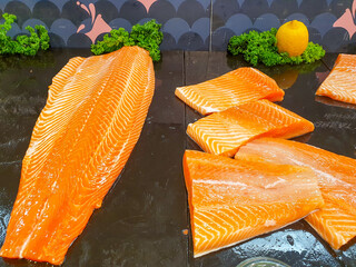 fresh salmon meat displayed on black shelf