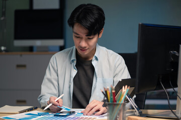 Male coder or developer working overtime using a computer display in problem solving at workplace.