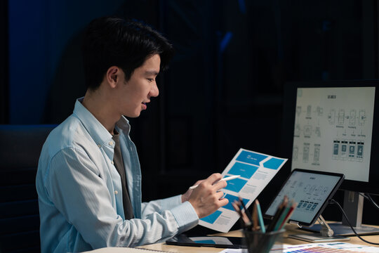 Male coder or developer working overtime using a computer display in problem solving at workplace.