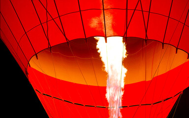 A powerful flame inflates a bright red balloon. A flight in Cappadocia, Turkey. Lighting the flame...