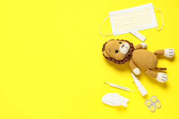 Toy lion with influenza test, thermometer and medicals on yellow background © Pixel-Shot