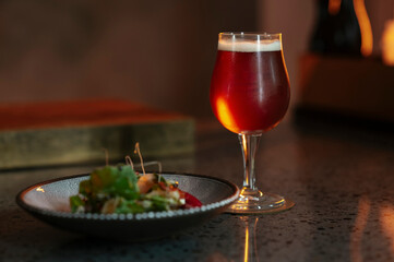 A glass of beer and a salad in a restaurant setting