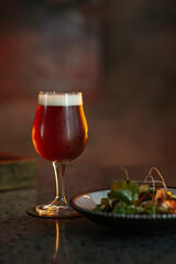 A glass of beer and a salad in a restaurant setting
