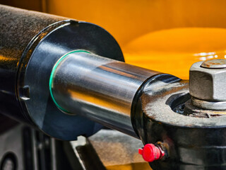 Close-up detail of hydraulic cylinder showcasing connection mechanism and working components in a workshop setting