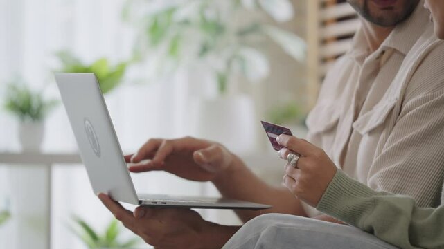 Couple using tablet and credit card to shop online through e-commerce app, making payment and browsing modern platform with promo codes and discount offers