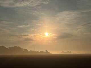 sunrise over the field a foggy morning