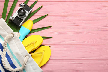 Composition with bottle of sunscreen cream and beach accessories on pink wooden background