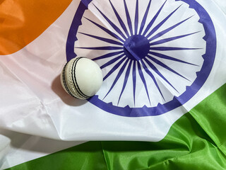 Cricket ball on the Indian flag top view, sports concept background. White ball cricket, stadium,...