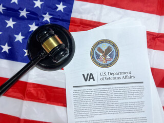Veteran affairs and gavel with the American flag in the backdrop, top view.