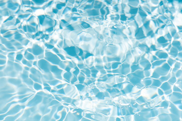 Fototapeta premium Blue water with ripples on the surface. Defocus blurred transparent blue colored clear calm water surface texture with splashes and bubbles. Water waves with shining pattern texture background.