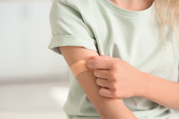 Little girl with medical patch after vaccination in clinic, closeup