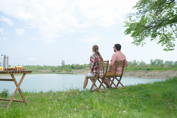 Family on picnic near the lake, looking at view