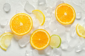 Ice cubes with slices of fresh citrus fruits on white background