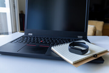 Smartwatch and notebook on laptop keyboard