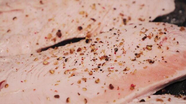 Cooking turkey breast with spices ground black pepper on pan close-up. Preparing healthy dinner at home. High quality 4k footage