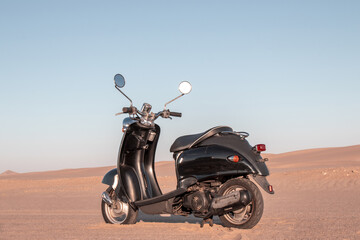 Black retro scooter in the Namib Desert at sunset — a bold mix of style, freedom, and timeless adventure. Perfect for travel, lifestyle, and vintage-themed campaigns.


