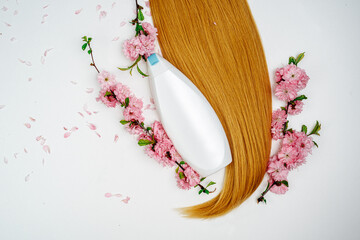 Shampoo, hair conditioner in a white jar on a white background. Mockup, space for text. Sakura flowers. Shampoo for normal hair, nutrition and protection with flower extracts