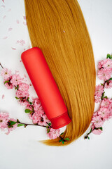 Shampoo, hair conditioner in a red jar on a white background. Mockup, space for text. Sakura...