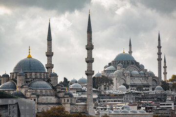 Fototapeta premium Istanbul skyline with Suleymaniye Mosque and Yeni Mosque under dramatic cloudy sky